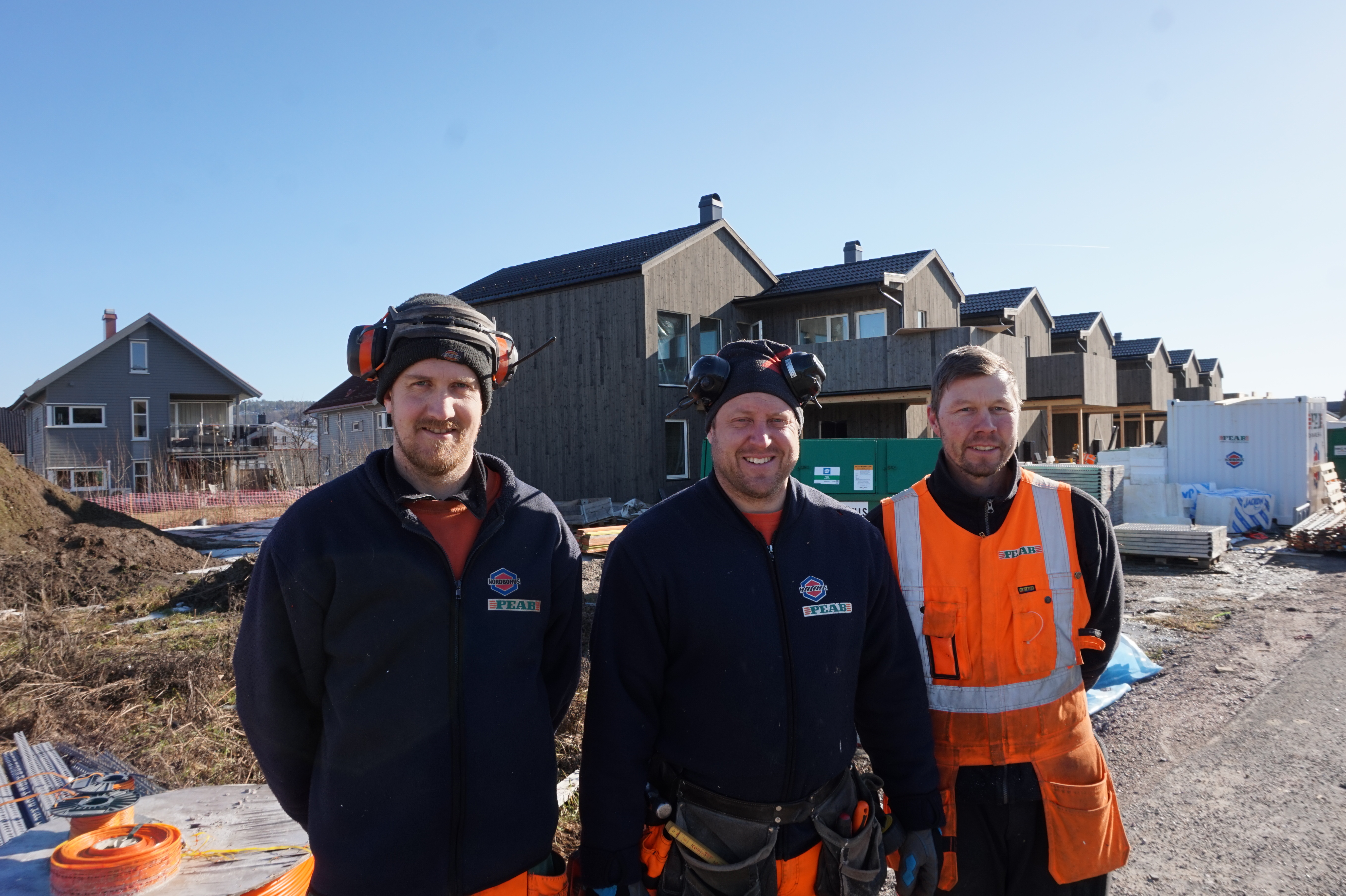 Tømrerlag i Peab Nordbohus Skien foran boligprosjekt