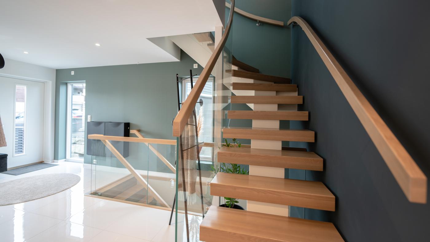 Moderne trapp med lyst treverk og glass i hus fra Nordbohus