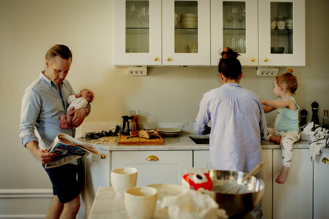 Familie på fire står på kjøkken i hus fra Nordbohus