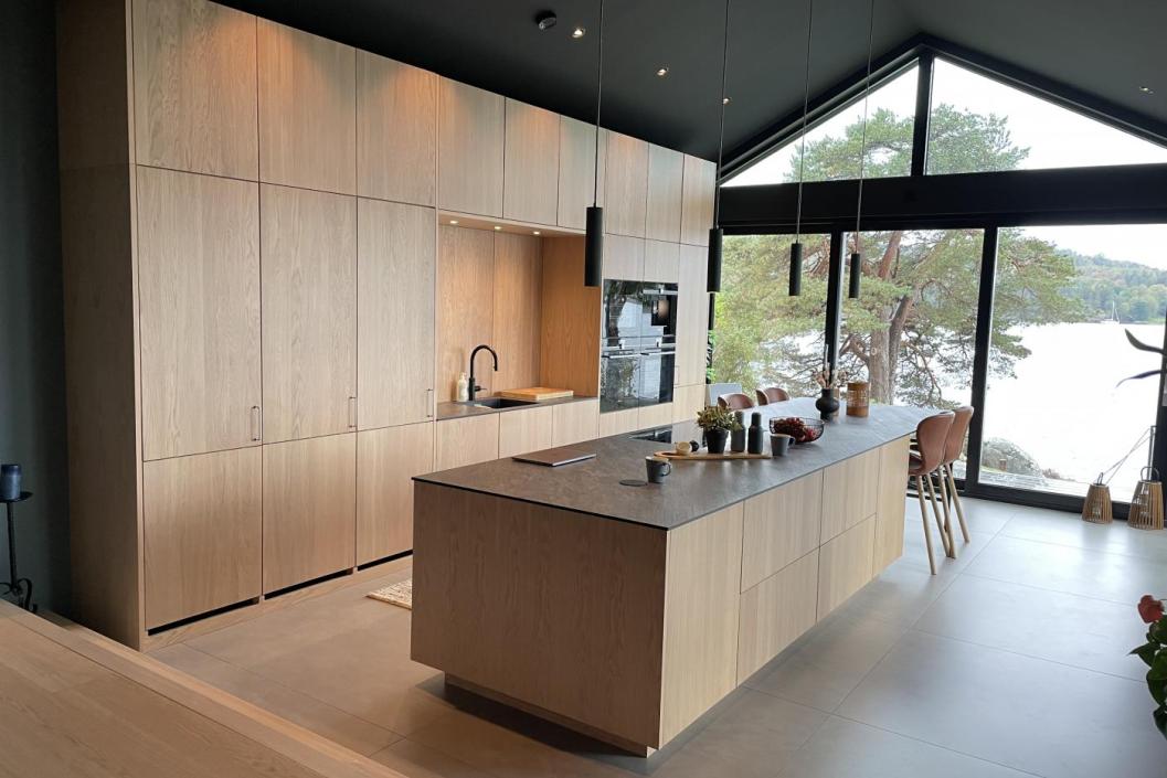 Stort og moderne kjøkken i lyst tre med kjøkkenøy