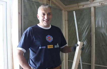 Einar Øvregard på en byggeplass med litt trevirke i hendene
