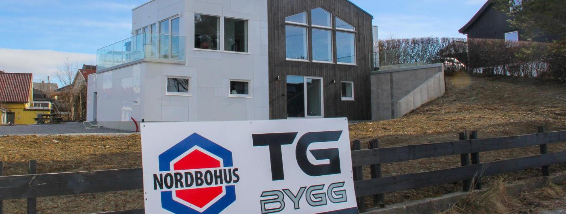Bilde av hus etter rehabiliteringsjobb av Nordbohus TG Bygg. Stort skilt på gjerdet fremfor boligen som promoterer Nordbohus TG Bygg.