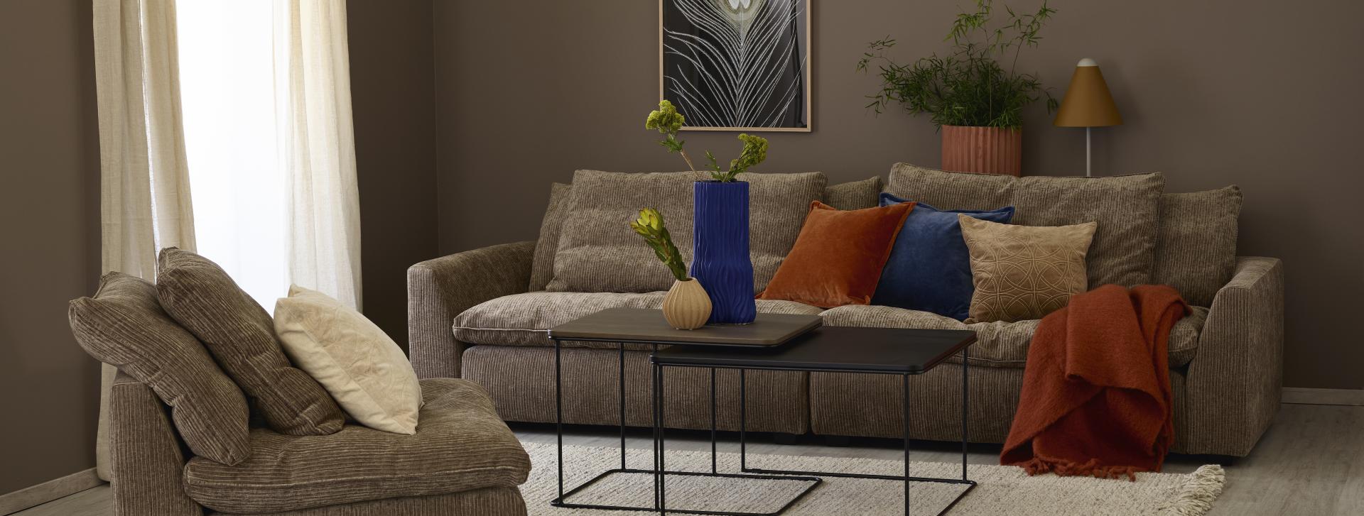Brunmalt stue med brun sofa og fargerike puter