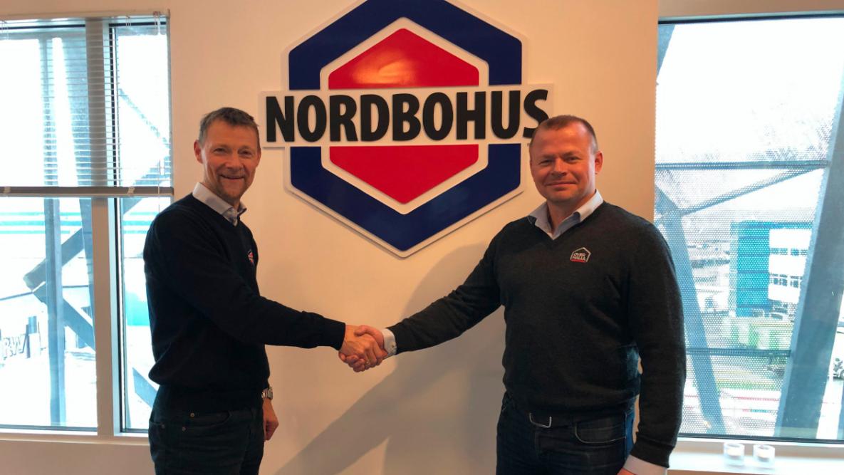 Birger Aspaas og Jomar Sagmo med handshake foran Nordbohus-logoen