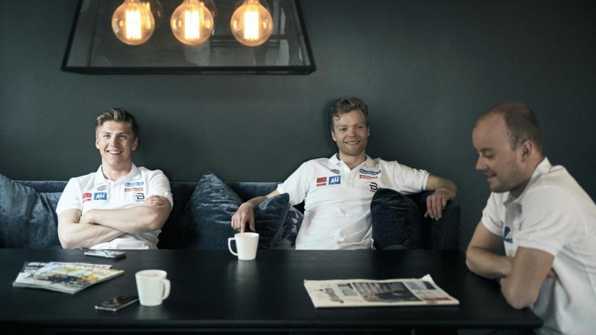  Langrennslandslagets Erik Valnes, Eirik Brandsdal og Sindre Bjørnestad Skar over en kaffekopp ved spisebordet.