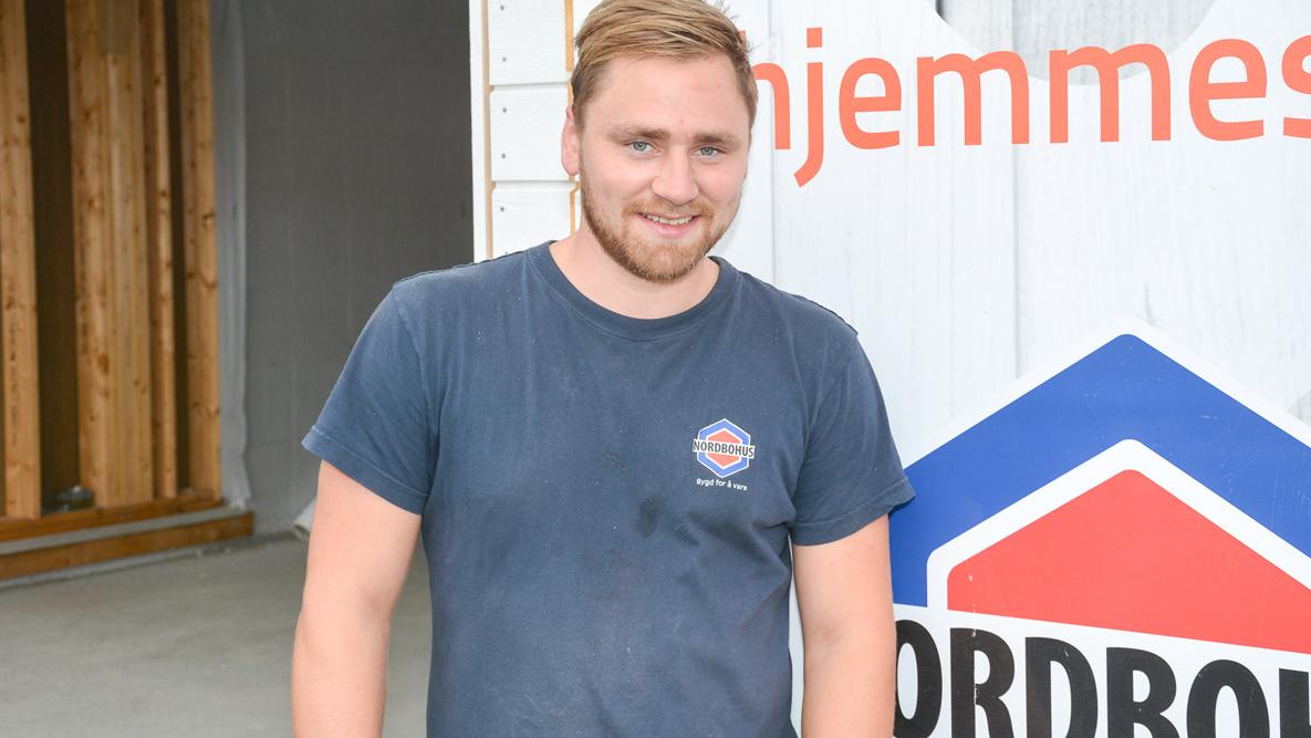Tømrer Daniel Madsen på byggeplass foran et Nordbohus-skilt