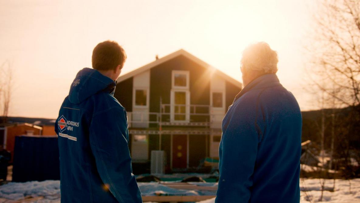 To tømrere fra Nordbohus foran et bygg under oppføring