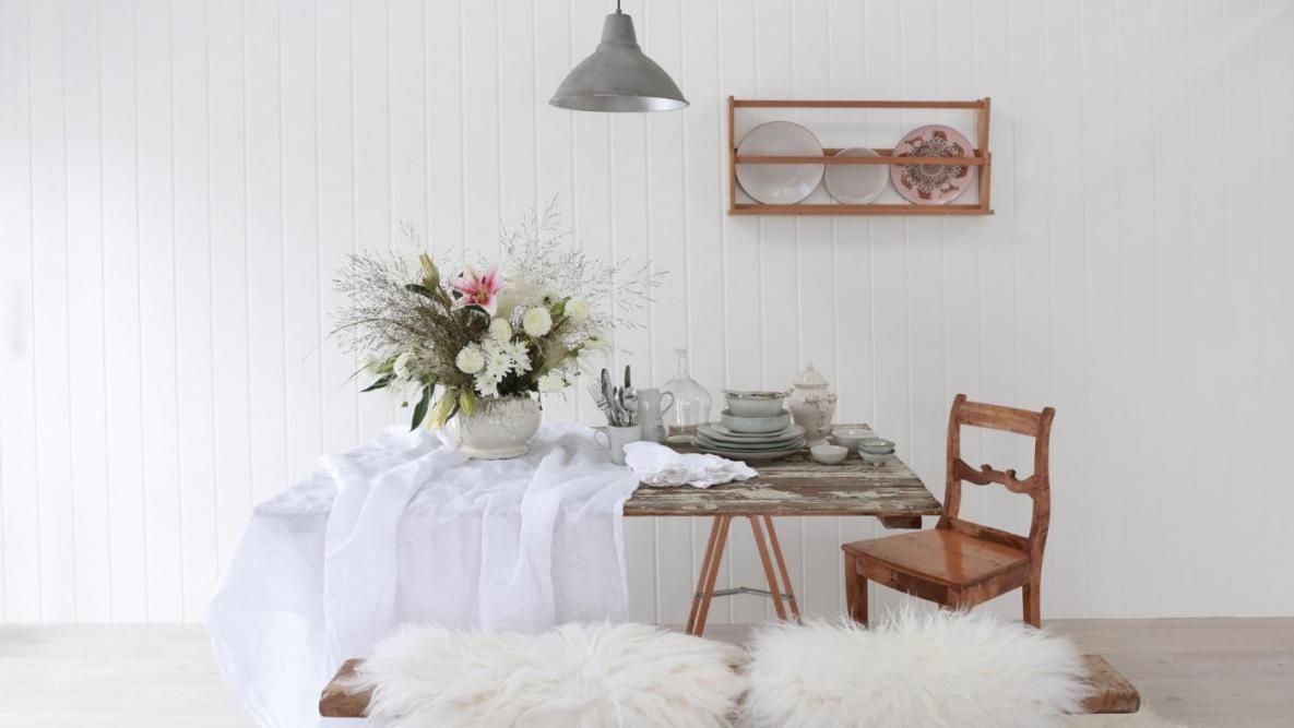 Huntonit veggplater, type skygge hvit. Et bord med blomster på og en stol til høyre.