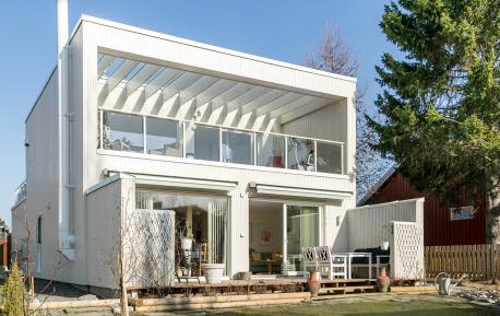 Hvitmalt arkitekttegnet enebolig med flott terrasse