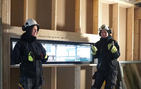 Tømrerlærling Erlend Åsen og hans kollega Kim André foran et vindu de nettopp har montert