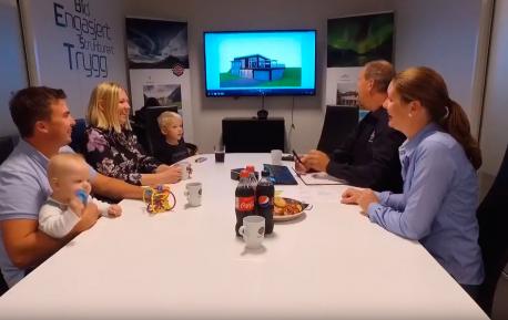 En familie på besøk hos Nordbohus Modum sammen med to salgsrepresentanter i et møterom
