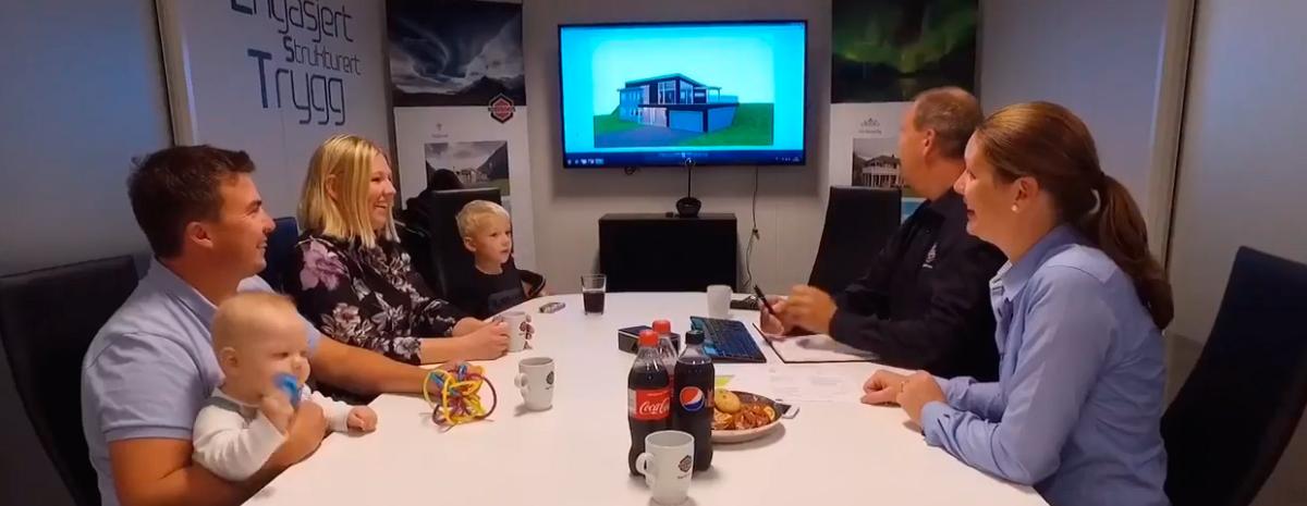 En familie på besøk i et møterom hos Nordbohus Modum sammen med representanter for firmaet