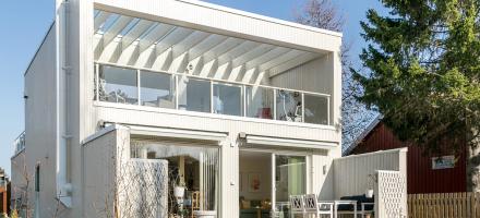 Hvitmalt arkitekttegnet enebolig med flott terrasse