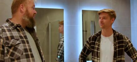 Gladsnekkern til venstre og kunden Marius til høyre. De står på badet. Bak dem er to speil med bakbelysning.